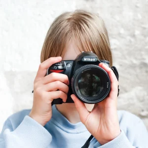 A girl is holding Nikon DSLR camera