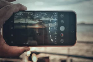 A hand holding an iPhone screen showing camera settings