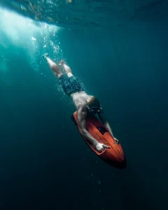 A photograph of Man Freediving in Sea with Underwater Scooter