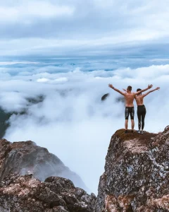Scenic photo of a couple standing on edge of cliff
