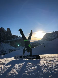 A photo of a person on snowboard at ski field at sunrise
