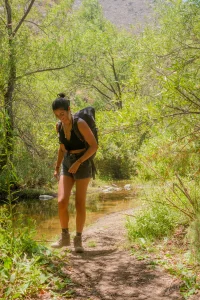a photo taking from a front view of a woman hiking in forest