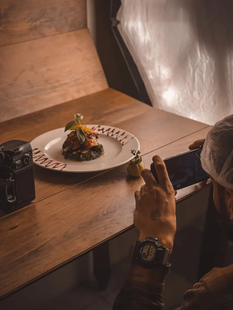 A person taking photo of the food by his phone