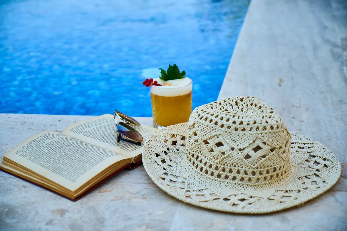A beige straw hat, with some accessories besides the pool