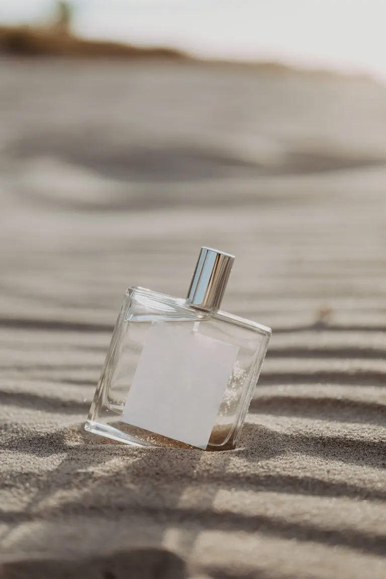 Glass perfume bottle on the sand