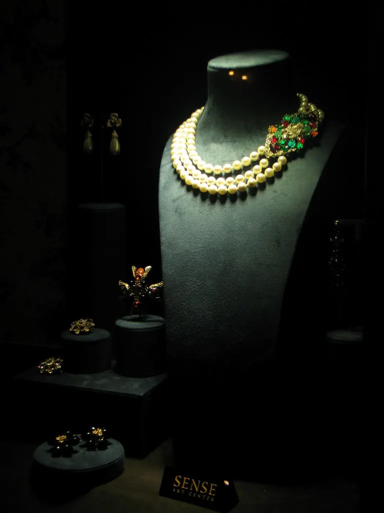 Low-key luxury item photograph of a pearl necklace on display