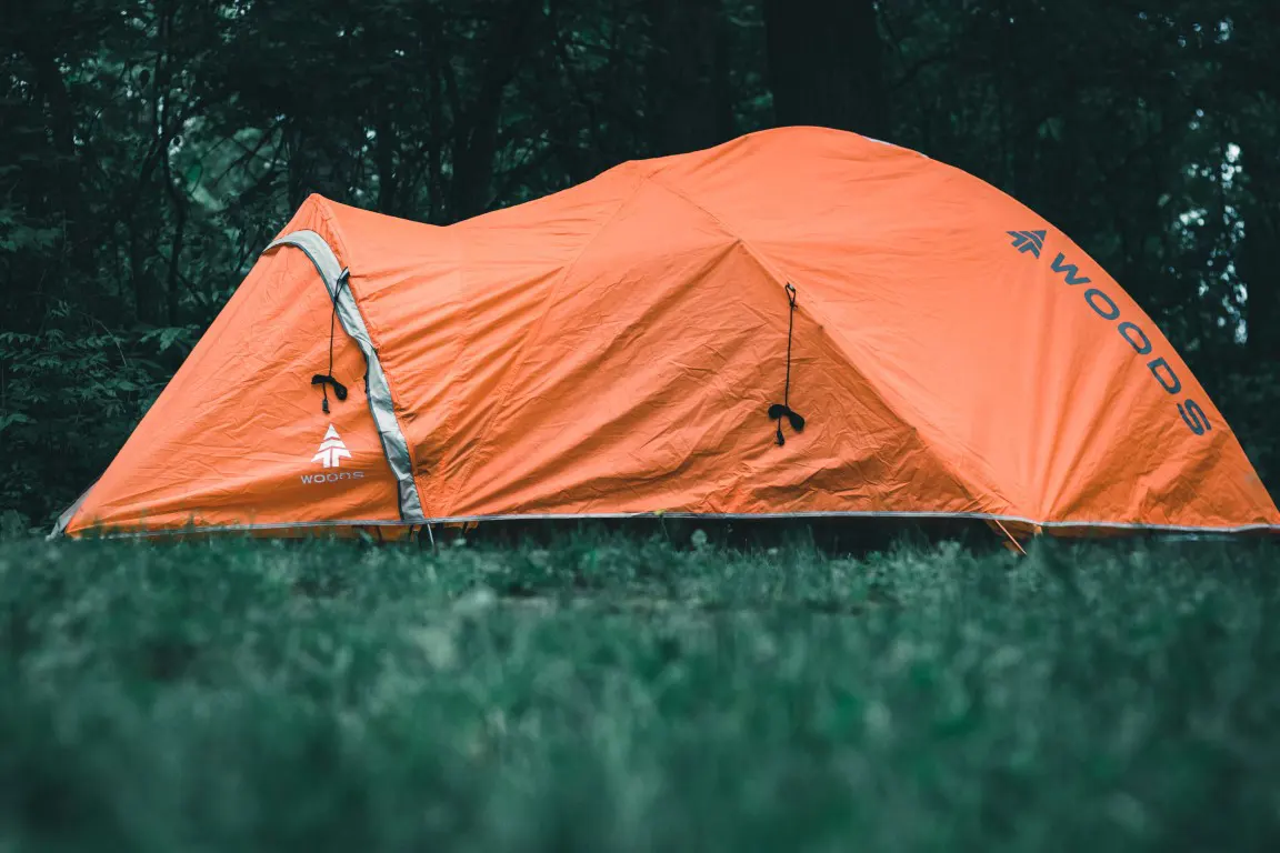Orange tent on a green grass field