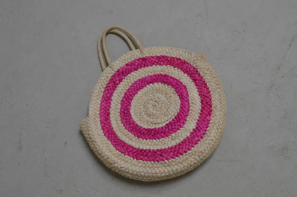 Round straw bag on the cement floor in rustic-style photography