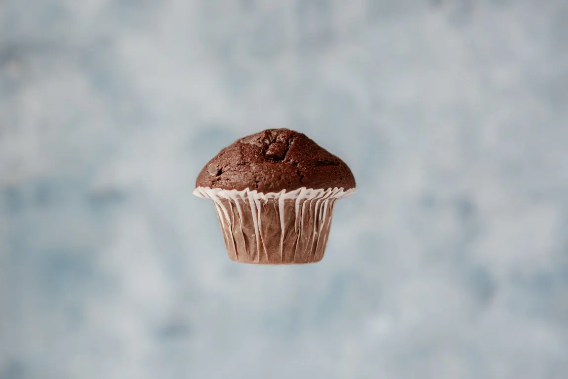Sweet chocolate muffin levitating in the air