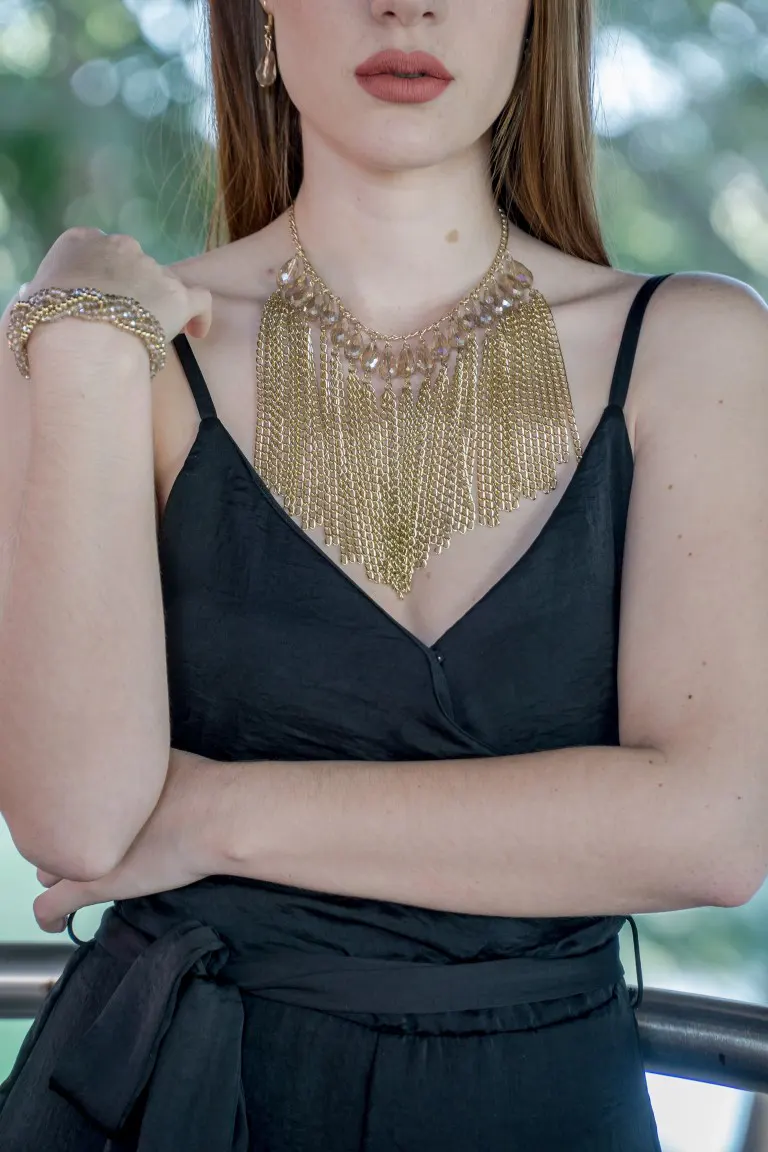 A woman wearing a gold chain Necklace