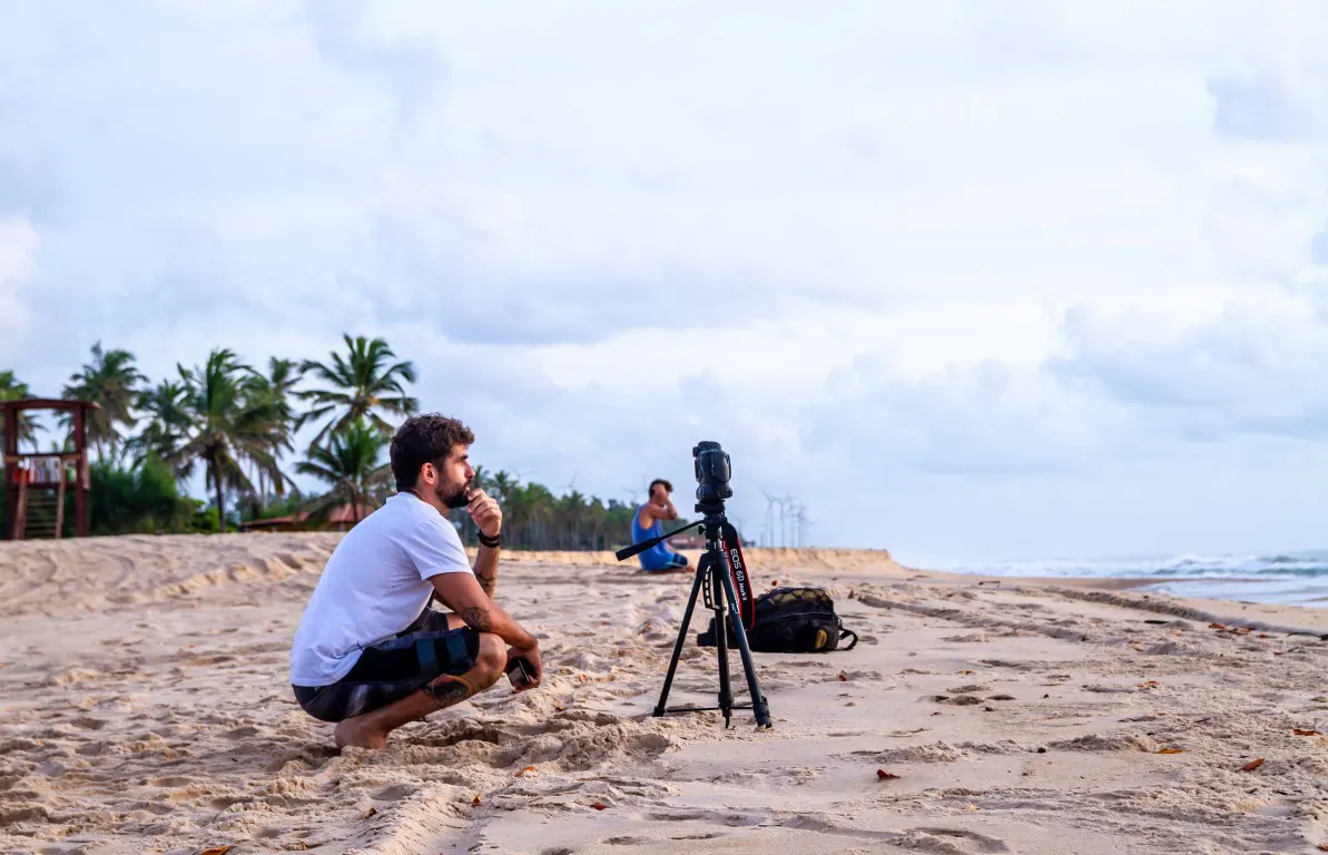 A man waiting to take a photo of the surfing with a camera setup with a tripod