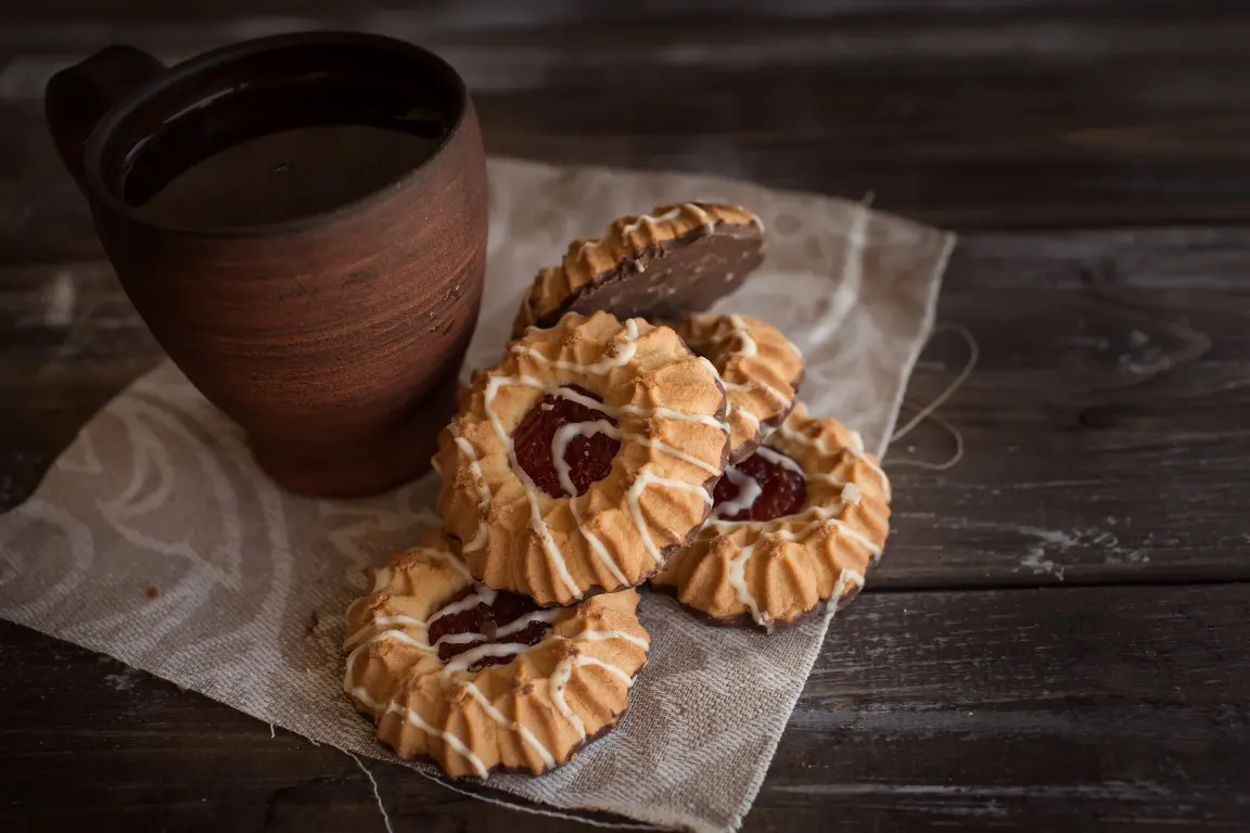 A food photo of cookies beside an old brown mug