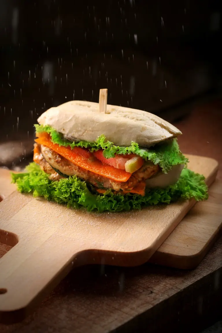 A food photo of a burger on top of wooden chopping boards