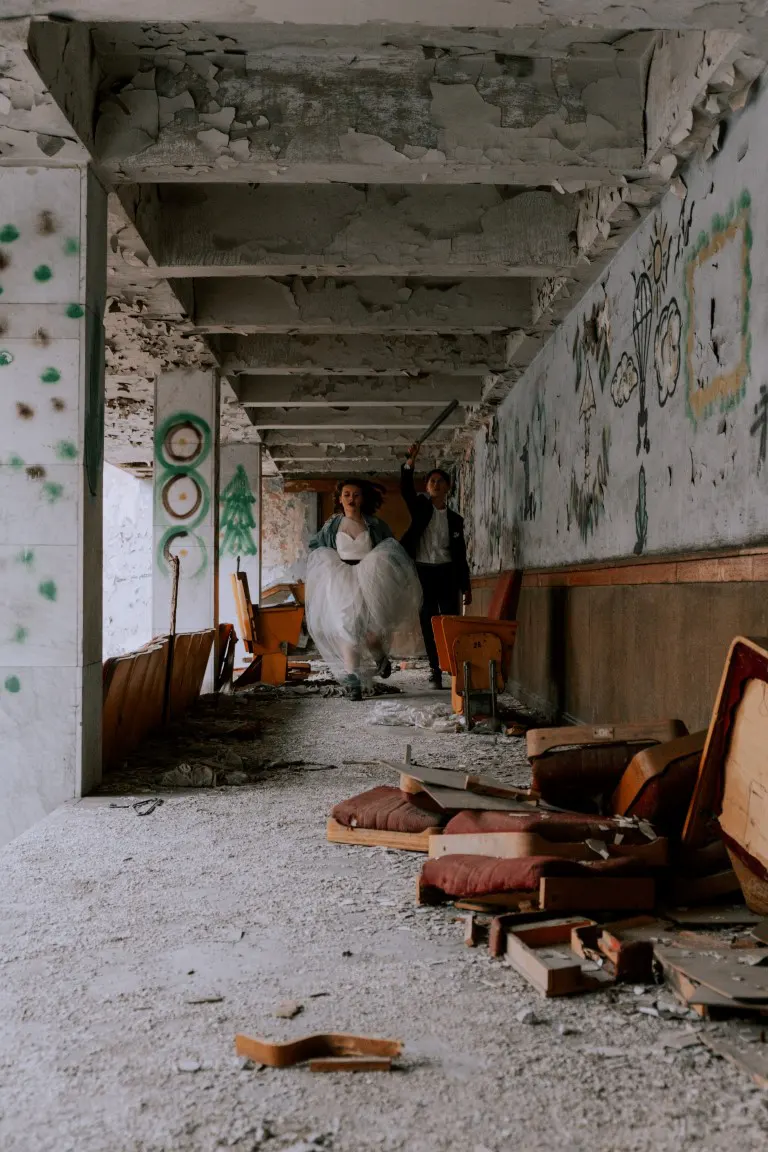A couple walking in a hallway of an abandoned building