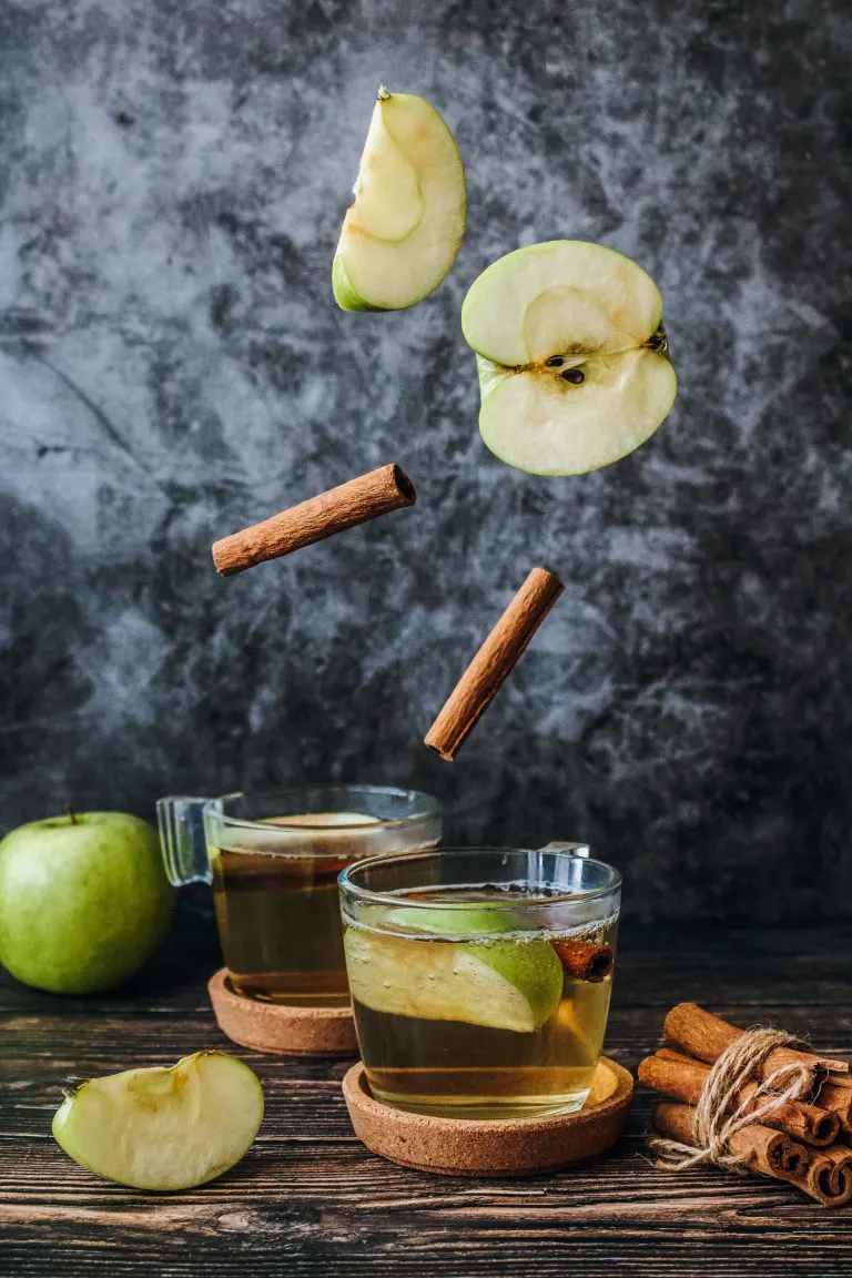 Food photo of tea with slice green apple and cinnamon stick