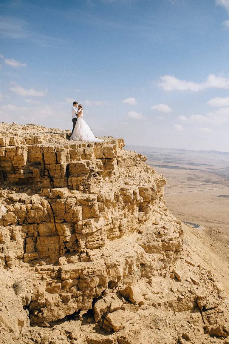 Bride and Groom Standing on Canyon Rock Cliff