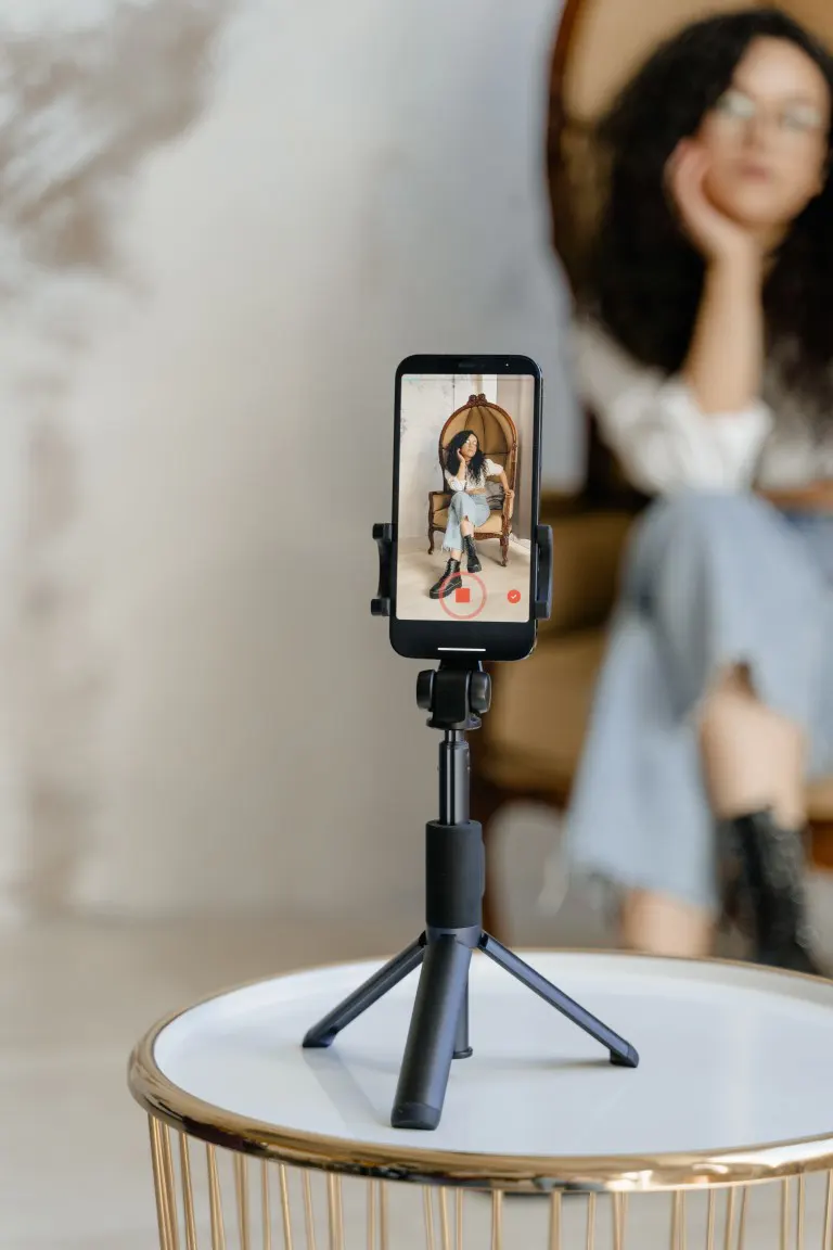 A photo of clothing product photography with a model using a smartphone with a tripod