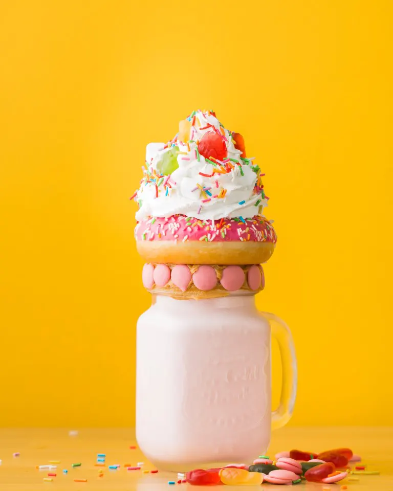 Food photo of a dessert on top of the jar with yellow color background