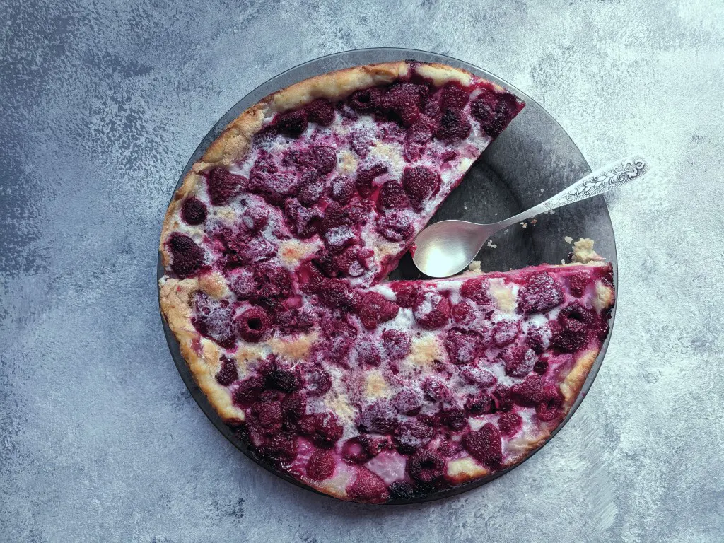 A food photo of a Raspberry pie on a textured backdrop