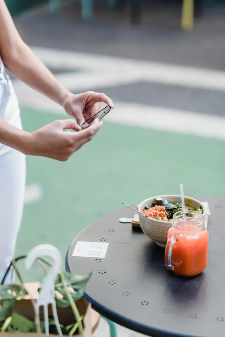 Taking photos of vegetarian food on a smartphone at outdoor