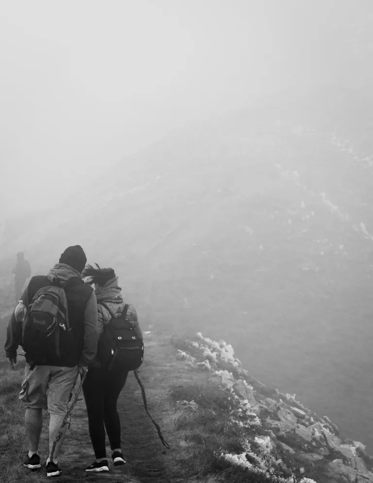 Grayscale photo of hikers a trail