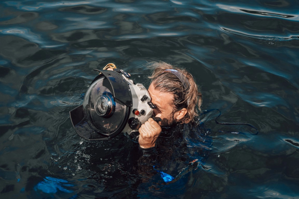 Holding a camera with underwater housing case before dive into water