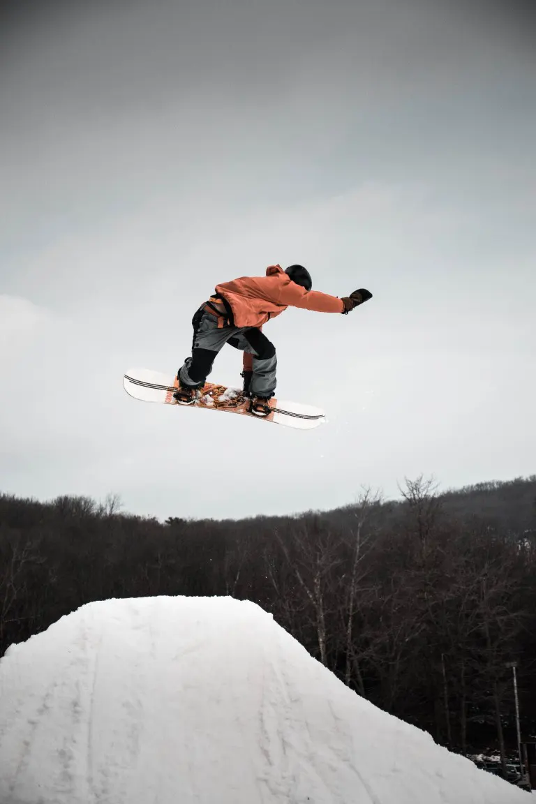 A man in snowboard jumping on ramp